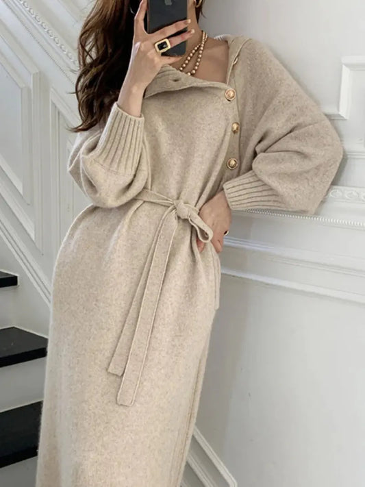Vestido vintage elegante con cuello tortuga en tono beige, diseño largo con cinturón y botones dorados, ideal para un look sofisticado y atemporal.